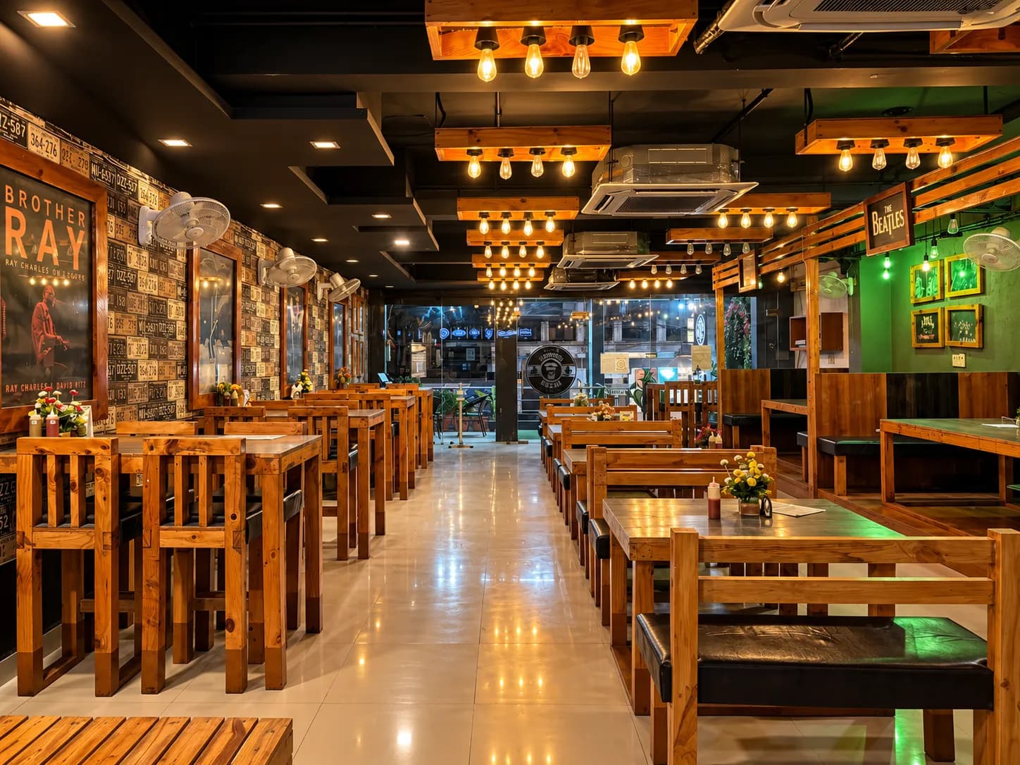 Burger Beans dining room: wooden booths under rows of warm Edison bulbs